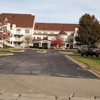 A view of a residential building with a parking area in front.