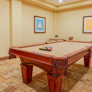 A cozy recreation room featuring a classic pool table with artwork adorning the walls.
