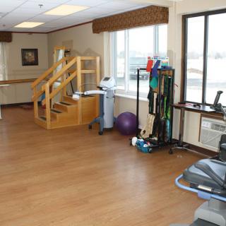 A well-equipped indoor gym space with various exercise and rehabilitation equipment.