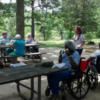 A group of elderly individuals enjoying a picnic in a park.