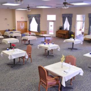 An empty dining room with neatly arranged tables and chairs.