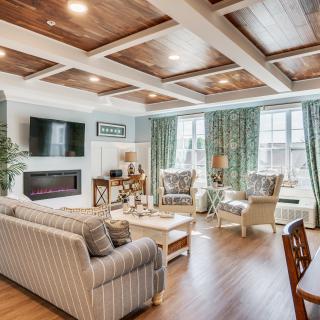 A cozy and stylish living room with a coffered ceiling, comfortable seating, and a modern fireplace.