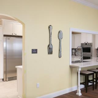 A modern kitchen with open concept design, featuring decorative wall art and stainless steel appliances.