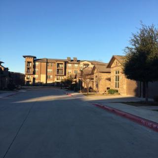 A suburban residential area with multi-story buildings under a clear blue sky.