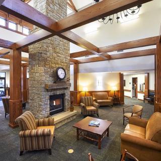 A cozy lobby with a central fireplace and comfortable seating.