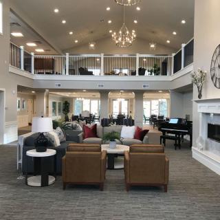 A spacious and modern lounge with a seating area, fireplace, and chandelier.