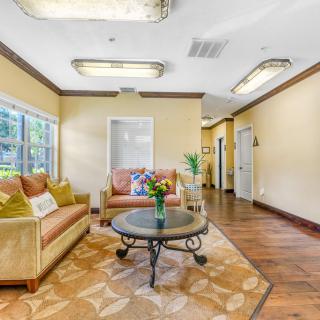 A cozy living room with comfortable sofas, a round coffee table, and large windows providing natural light.