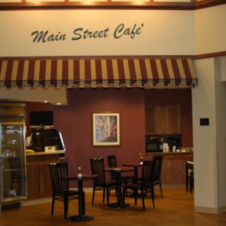 A cozy cafe setting featuring a seating area and a welcoming sign.