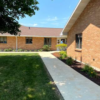 A well-maintained residential building with a landscaped yard and a clear pathway.