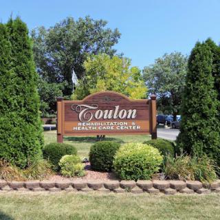 Welcome to Coulton: A Charming Town Sign Surrounded by Lush Greenery.