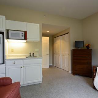 A cozy apartment with a small kitchen area and living space.