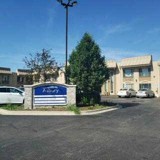 A view of a hotel or motel with clear blue skies and a parking area.