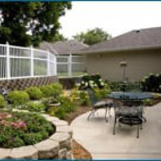 A well-maintained garden with a patio area featuring outdoor furniture and decorative landscaping.