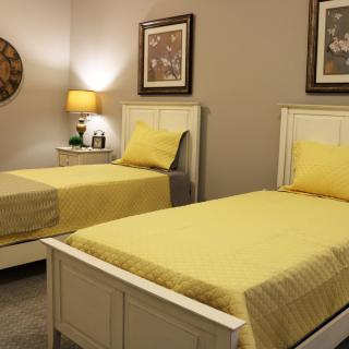 A cozy bedroom featuring twin beds with yellow bedding and stylish decor.