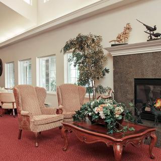A cozy living room with elegant armchairs, a coffee table, and a fireplace.