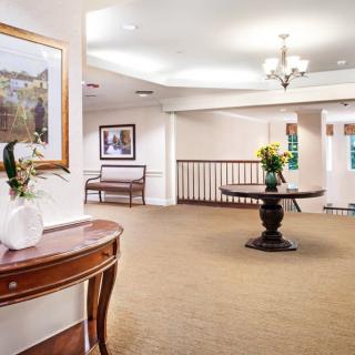 A spacious lobby area with elegant furniture and artwork on the walls.