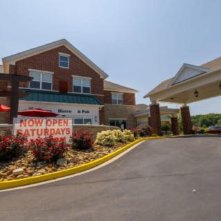 A hotel entrance with a visible banner reading 'Now Open Saturdays'.