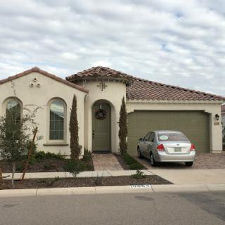 A charming residential house with a garage and landscaped front yard.