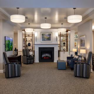 A modern living room with comfortable seating, a central fireplace, and stylish lighting.