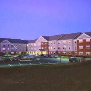 A modern apartment complex illuminated during the evening.