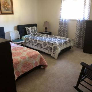 A cozy bedroom with two twin beds and a rocking chair.