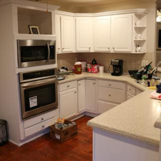 A cozy kitchen with white cabinets and modern appliances.