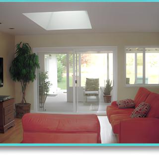 A cozy living room with red sofas and natural light from a skylight.