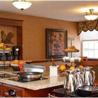 A cozy kitchen setup with a breakfast buffet on the countertop, featuring various food items and a coffee station.