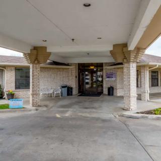 Entrance to a building with a covered driveway and brick exterior.