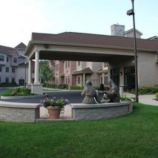 A welcoming residential building featuring a landscaped entrance with sculptures.