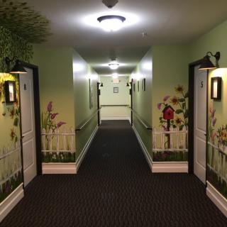 A hallway with painted walls, featuring decorative elements and doors on either side.
