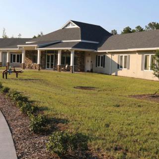 A spacious residential building with a well-maintained lawn on a sunny day.