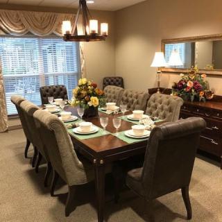 A beautifully set dining table with elegant chairs and lighting.