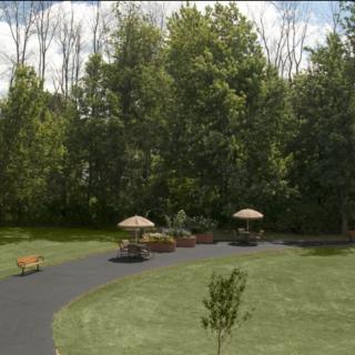 A scenic park with lush greenery, a paved pathway, and benches for relaxation.
