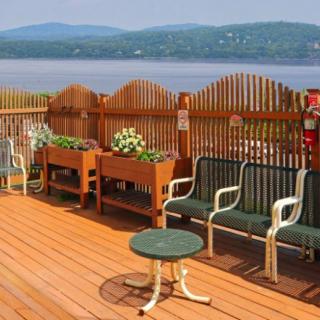 A scenic outdoor deck overlooking a lake, featuring seating and planters.