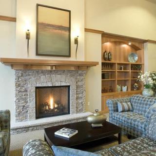 A cozy living room with a stone fireplace and comfortable seating.