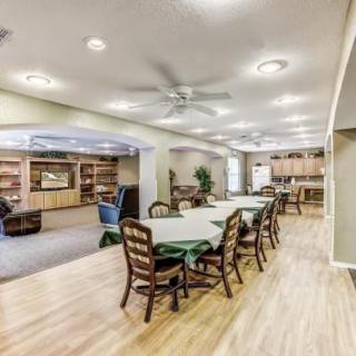 A spacious open floor plan featuring a dining area, living room, and kitchen with wooden floors and modern furnishings.