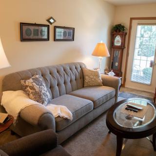 A cozy living room with a comfortable sofa, coffee table, and warm lighting.