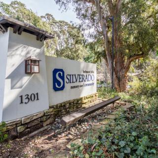Entrance sign for Silverbaron surrounded by nature and trees.