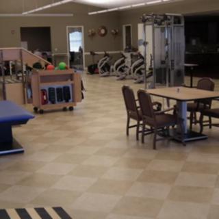 A rehabilitation center with exercise equipment and seating areas.