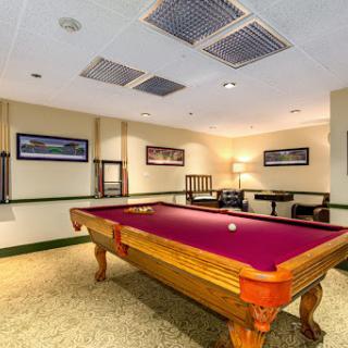 A cozy game room featuring a classic pool table with a rich purple felt.