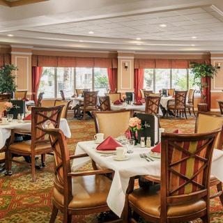 An elegant dining area with neatly arranged tables and chairs, set for a meal.