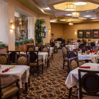 An elegant restaurant dining room with neatly arranged tables and chairs.