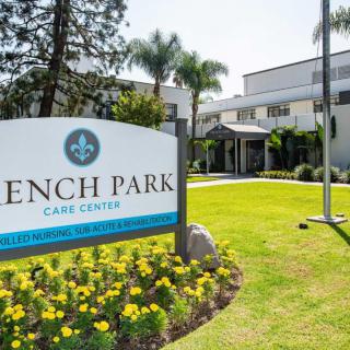 A nursing home building with a sign reading 'French Park Care Center', surrounded by well-maintained landscaping.