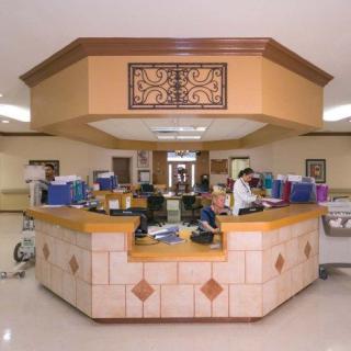 A nurse station in a hospital, equipped with medical supplies and staff working.