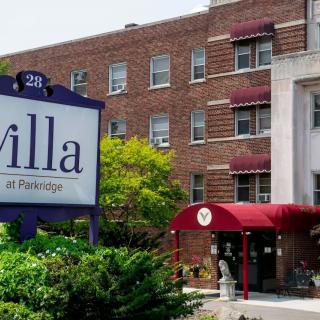 A brick building with a red entrance canopy and a sign that reads 'Villa Rehabilitation and Nursing Center'.