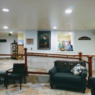 A cozy living room area featuring a sofa, chairs, and a painting on the wall.