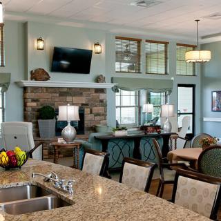 A spacious and modern open floor plan featuring a kitchen with granite countertops, island seating, and a living area with a fireplace.