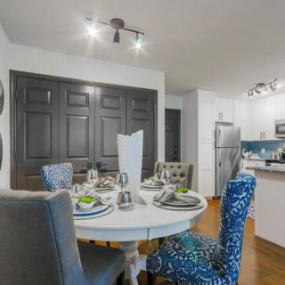 A modern dining area with a stylish table setting and an open kitchen in the background.