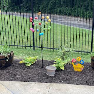 A vibrant garden display featuring colorful decorations and various plants.